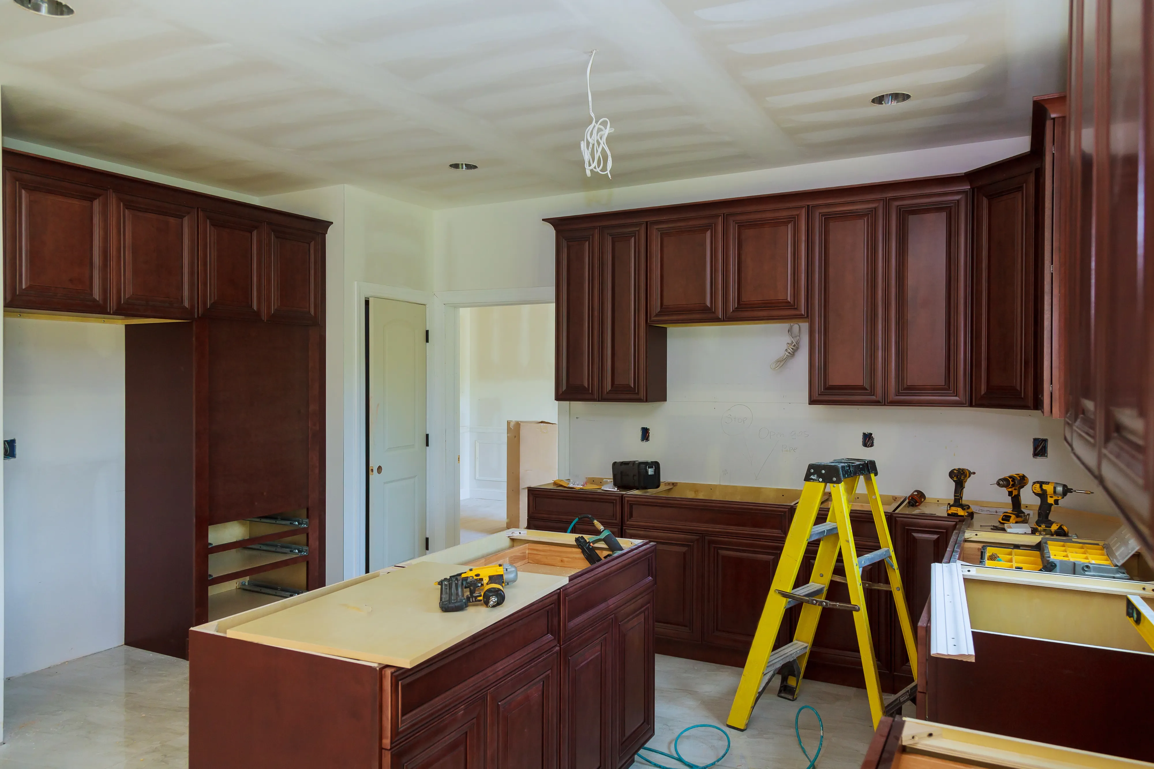 Kitchen renovation work in Los Angeles with contractor installing cabinets, countertops, and interior finishes