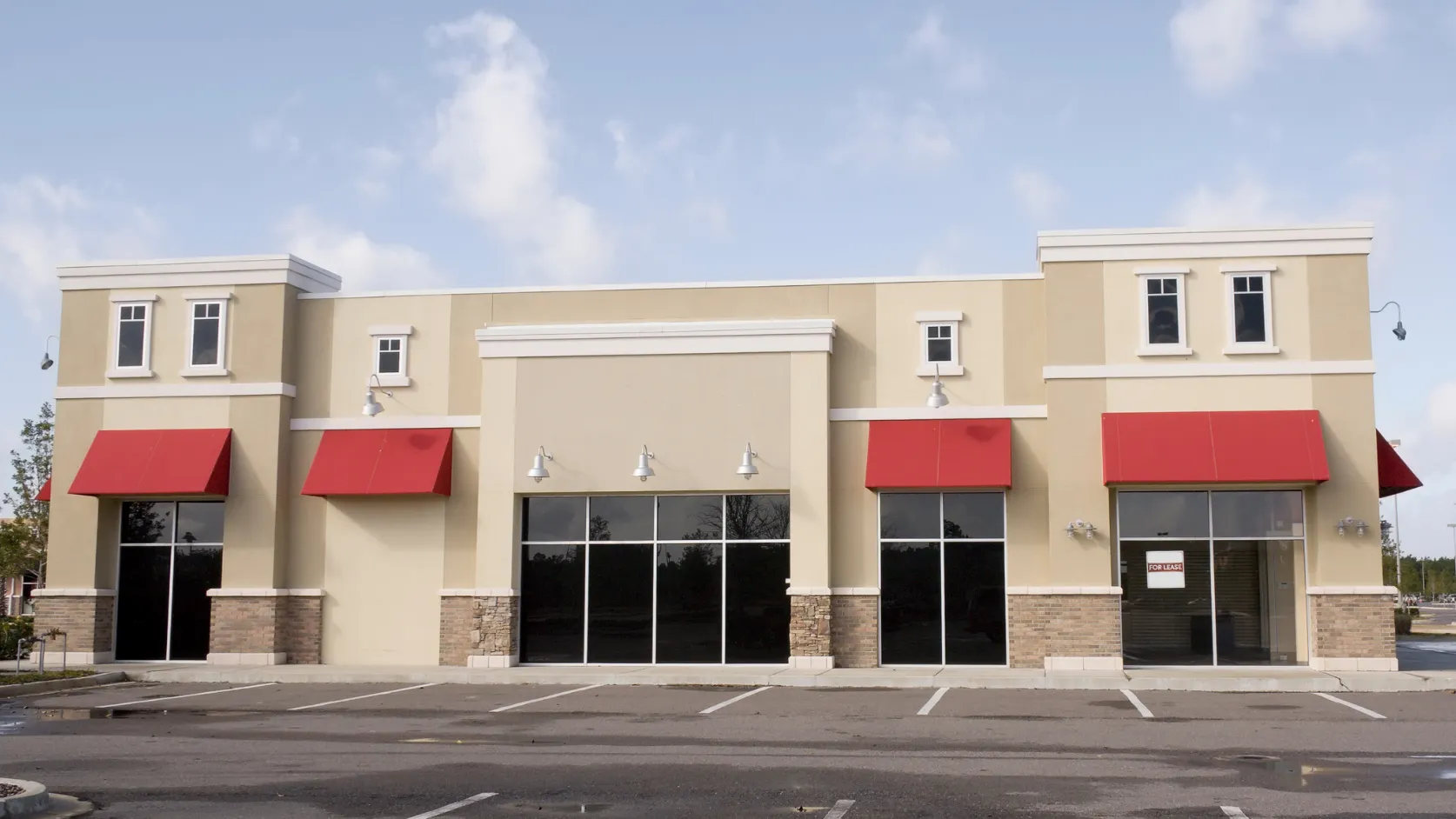 After commercial remodeling project in Los Angeles with updated storefront exterior, clean stucco facade, red awnings, glass windows, and improved business curb appeal