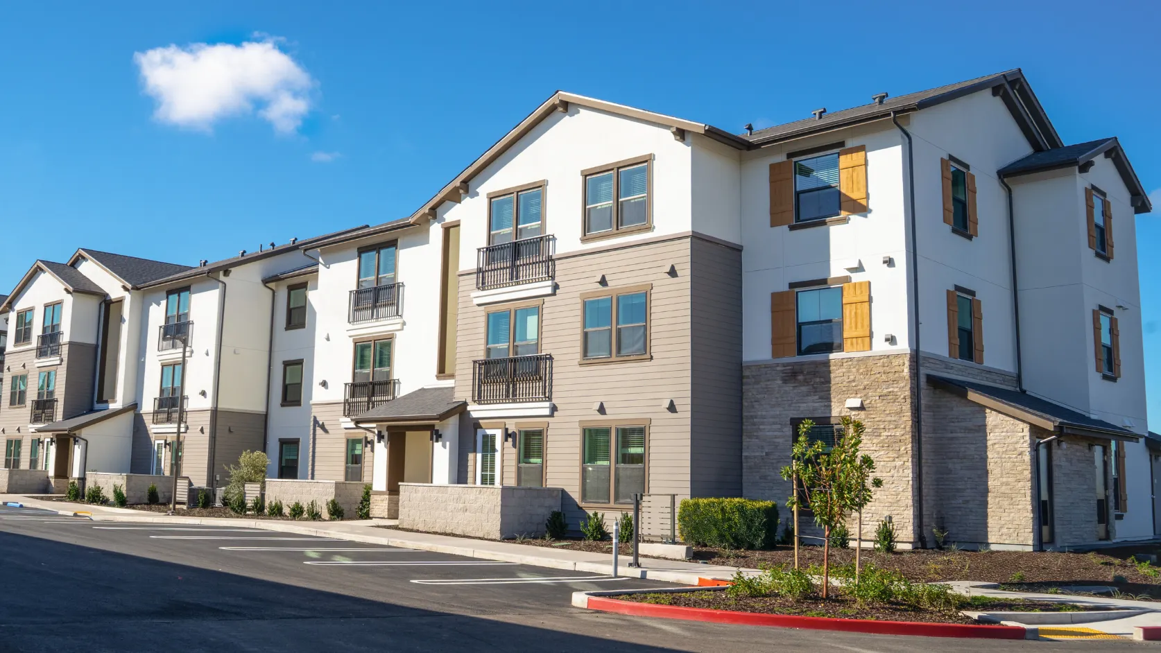 After condo remodeling project in Los Angeles with updated multifamily exterior, refreshed facade, modern windows, balconies, stone accents, and improved property appeal