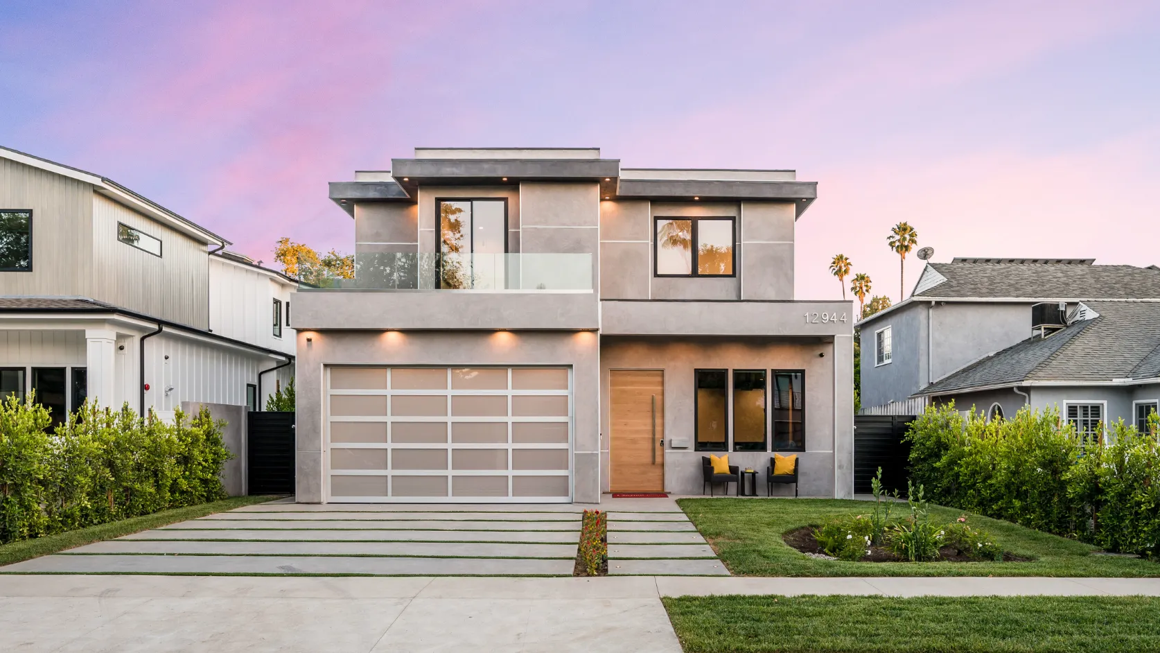 After full home remodeling project in Los Angeles with modern exterior renovation, updated facade, glass balcony, new garage door, landscaping, and improved curb appeal