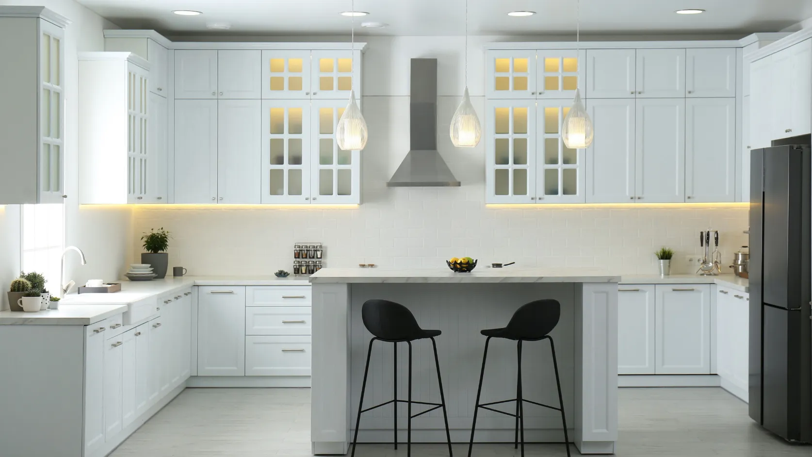 After kitchen remodeling project in Los Angeles with white custom cabinets, center island, pendant lighting, modern backsplash, and upgraded kitchen finishes