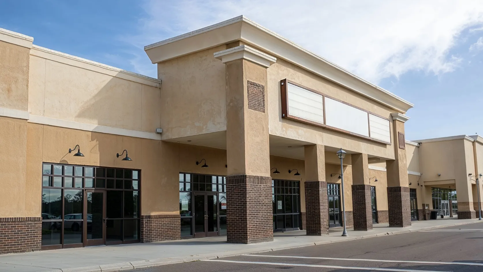 Before retail remodeling project in Los Angeles with dated storefront exterior, older brick columns, worn facade finishes, dark window frames, and outdated commercial building appearance