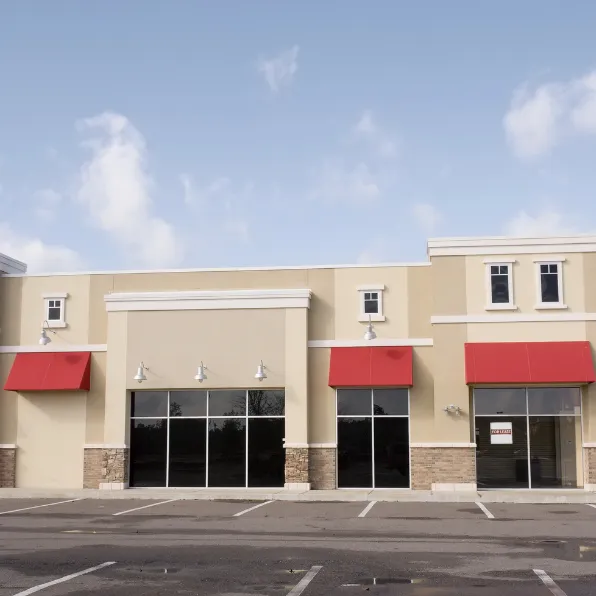 Commercial remodeling project in Los Angeles with shopping center storefront upgrades, glass entry doors, red awnings, stone accents, and business property improvements