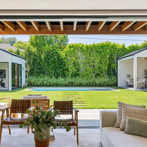 Outdoor living remodeling project in Los Angeles with backyard pool, patio seating, green lawn, indoor outdoor flow, and modern exterior living space