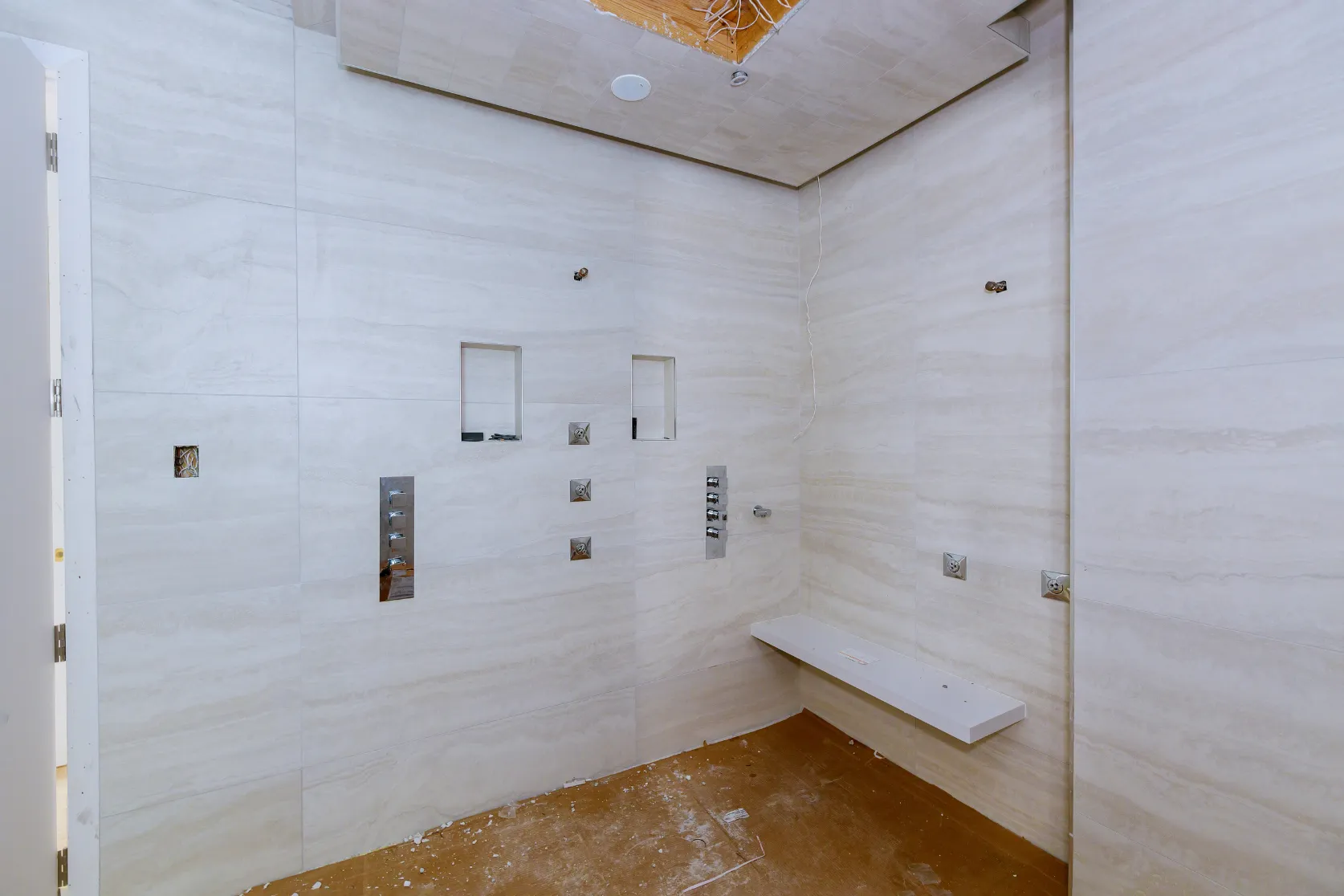Bathroom remodeling in Los Angeles with large-format shower tile installation, wall niches, plumbing fixtures, and walk-in shower preparation