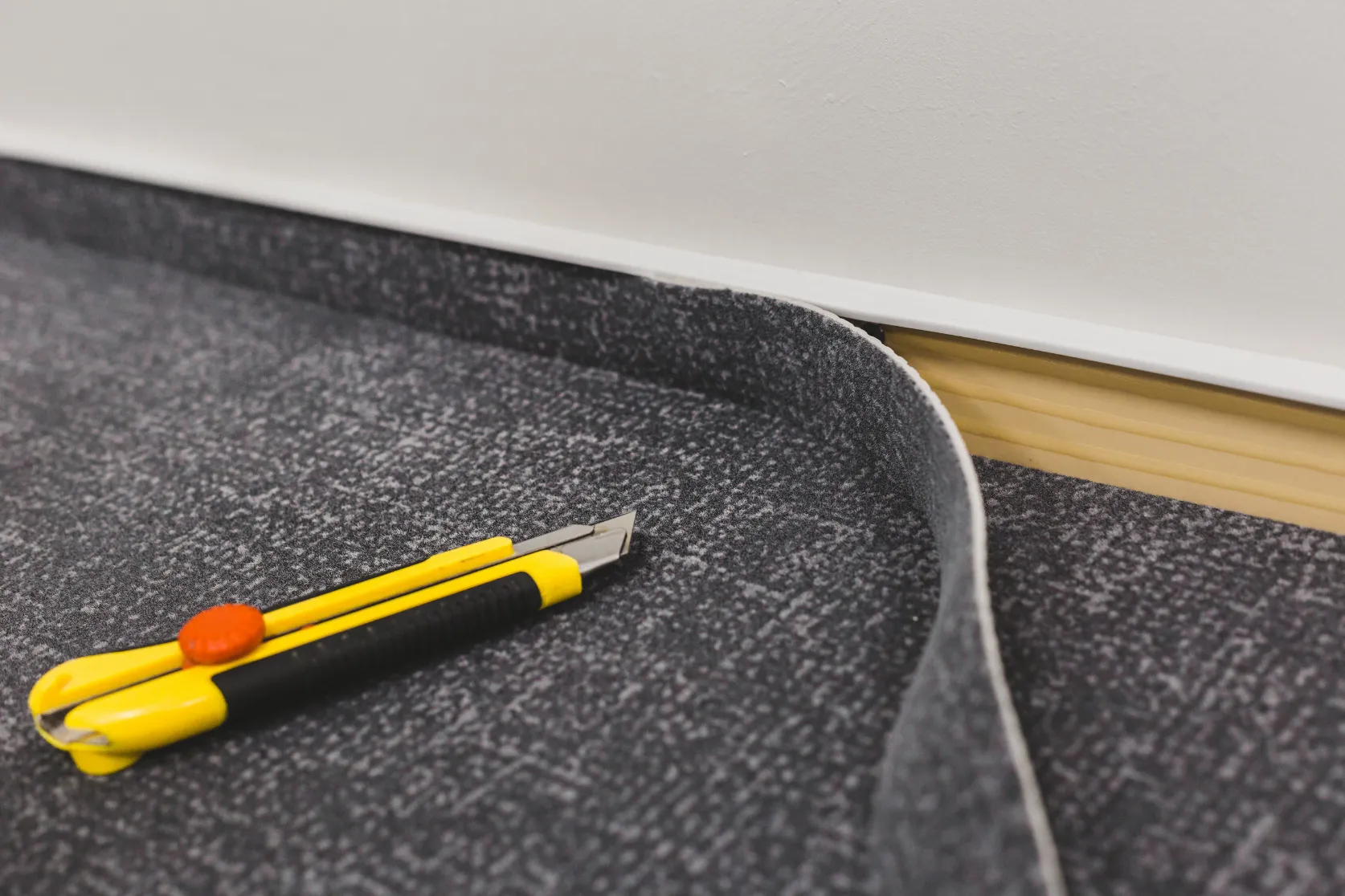 Commercial remodeling in Los Angeles with flooring installation detail, carpet tile preparation, cutting tools, and interior finish upgrades