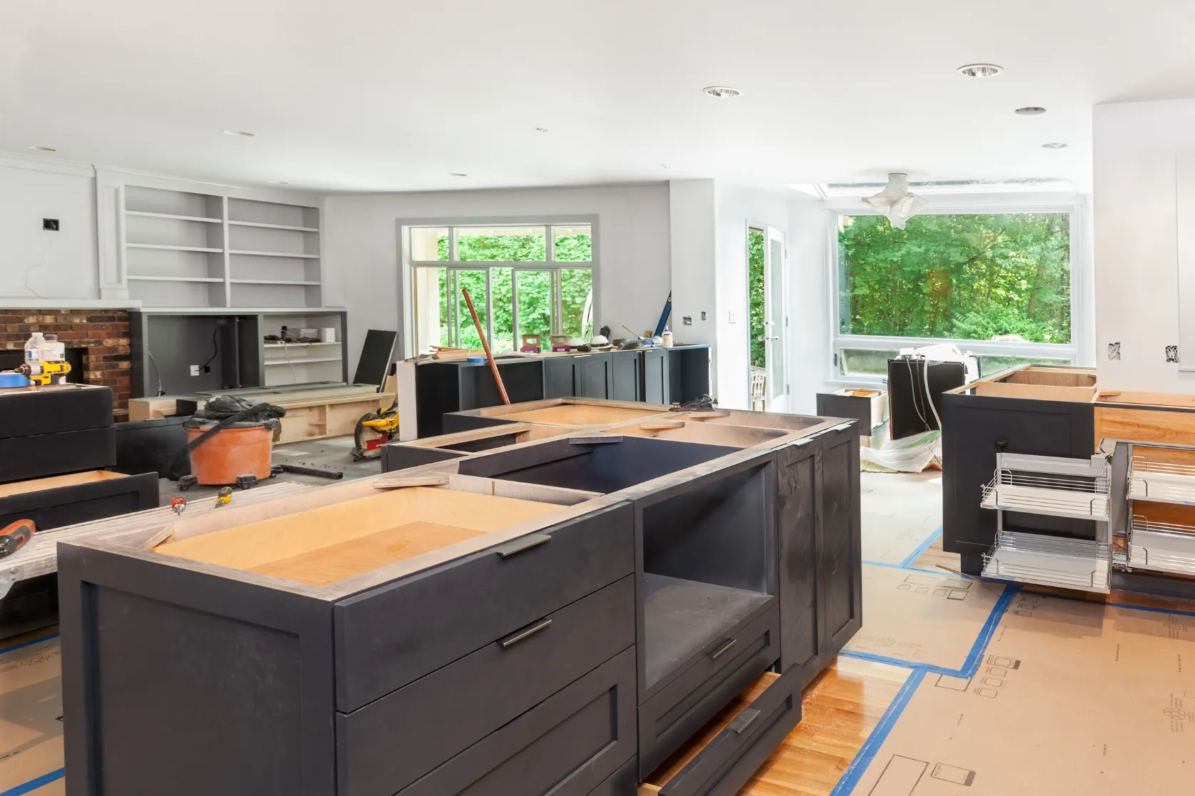 Full home remodeling in Los Angeles with open kitchen and living room renovation, cabinet installation, protected flooring, lighting, and finish preparation
