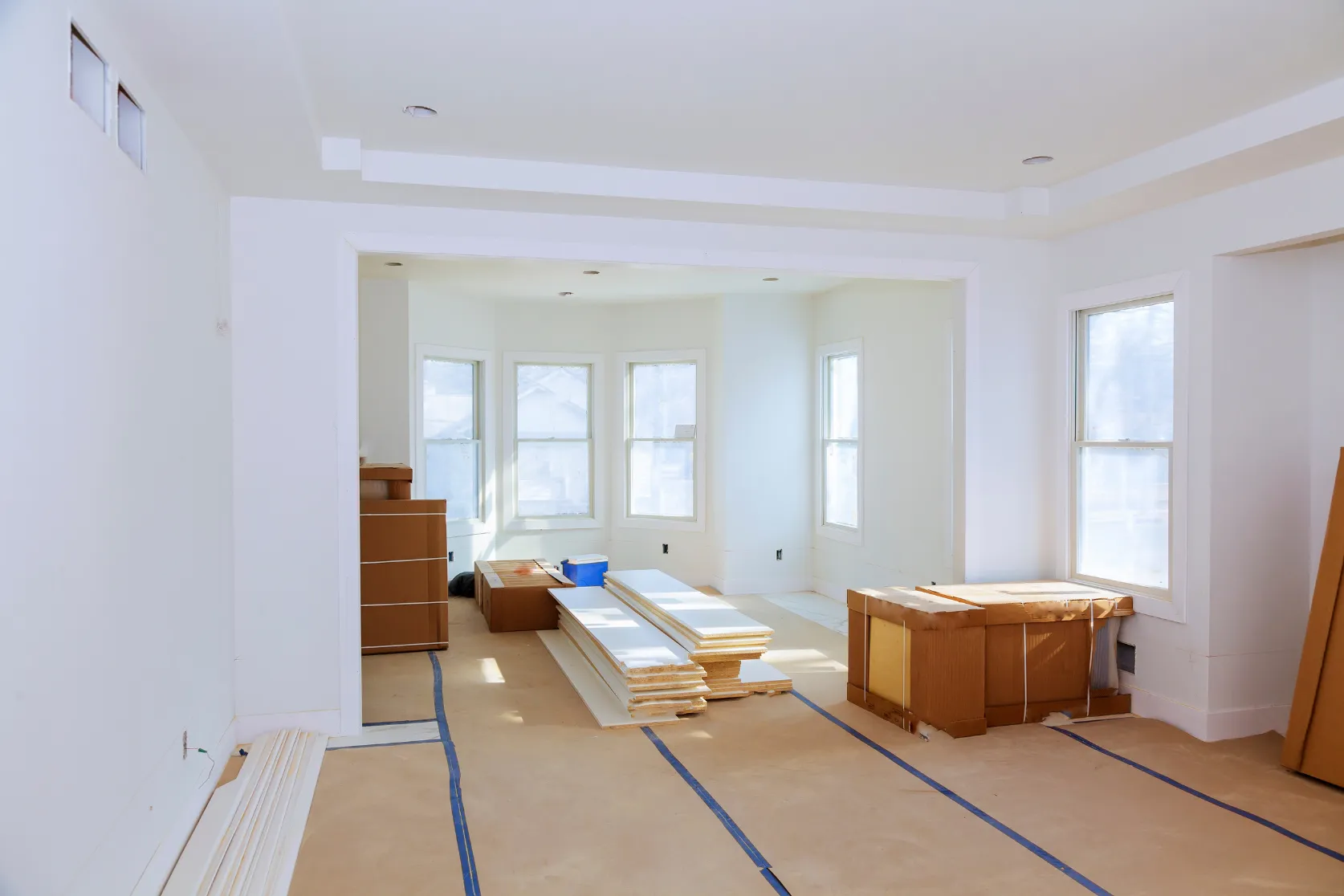 Los Angeles home remodeling with open living room renovation, bright interior walls, protected floors, and finish materials ready for installation