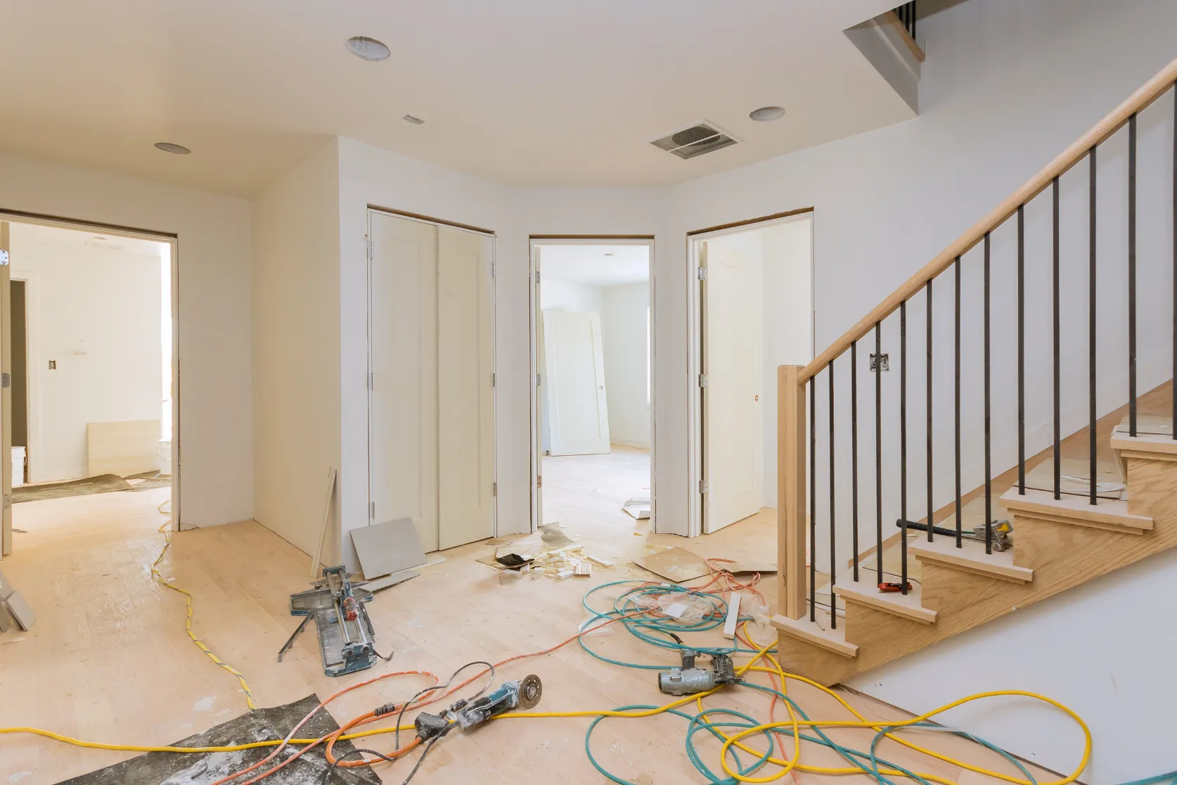 Interior remodeling in Los Angeles with staircase railing, hallway flooring upgrades, trim details, tools, and finish preparation