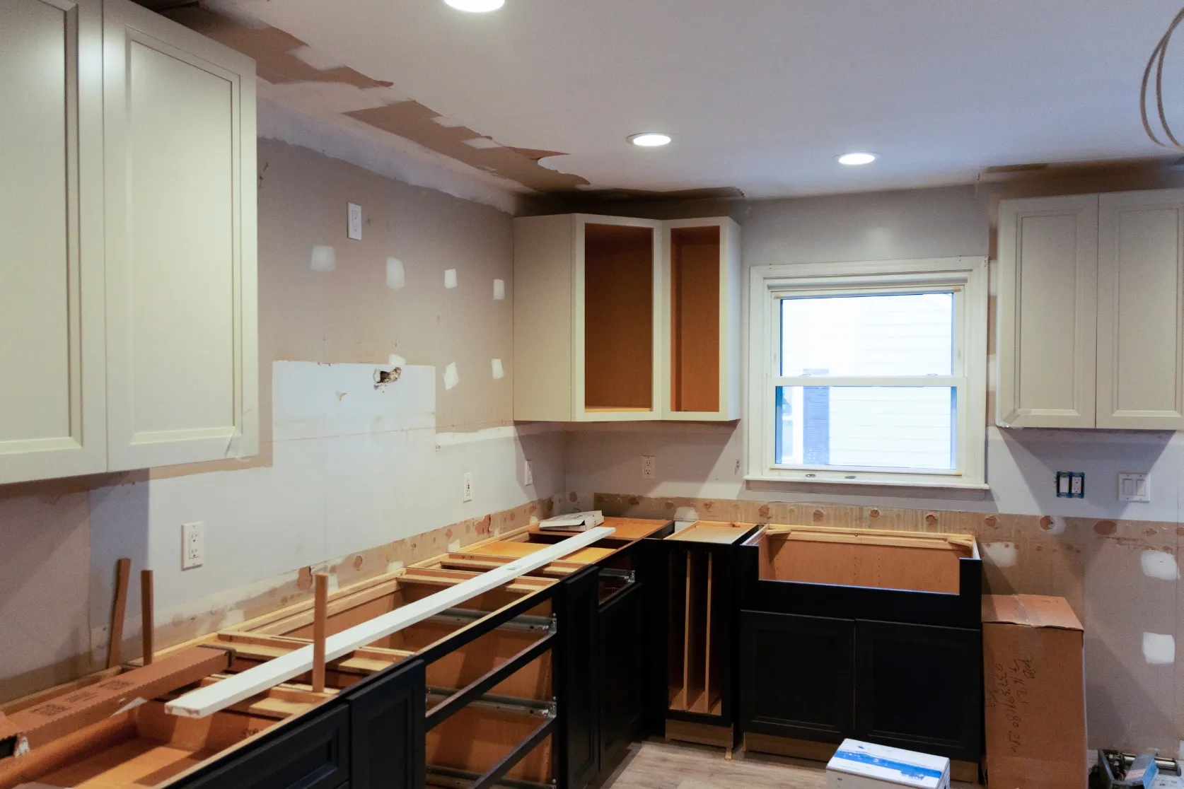 Kitchen remodeling in Los Angeles with cabinet installation, wall preparation, recessed lighting, window trim, and renovation work before final finishes