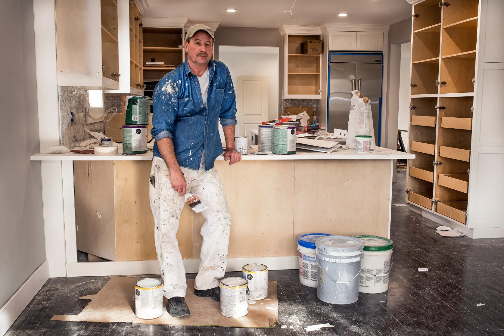 Kitchen remodeling in Los Angeles with contractor finishing custom cabinets, kitchen island surfaces, paint details, and renovation work